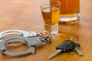 Shot glass with car keys and handcuffs